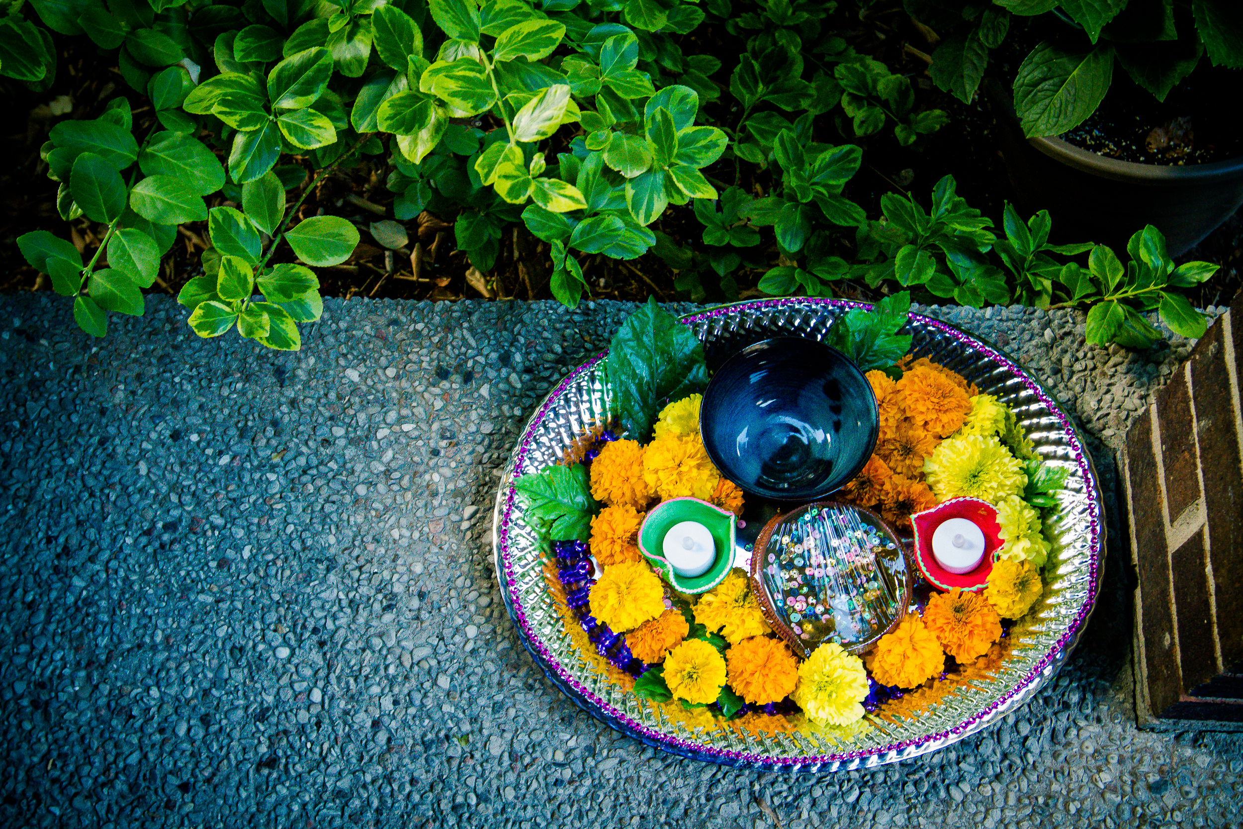 Traditional wedding tray with flowers, candles, and ceremonial items arranged outdoors