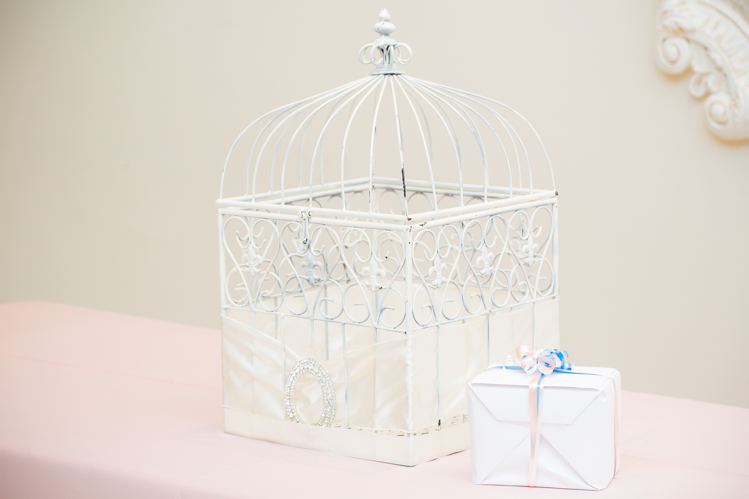 Decorative wedding gift display with a white birdcage and wrapped favor box