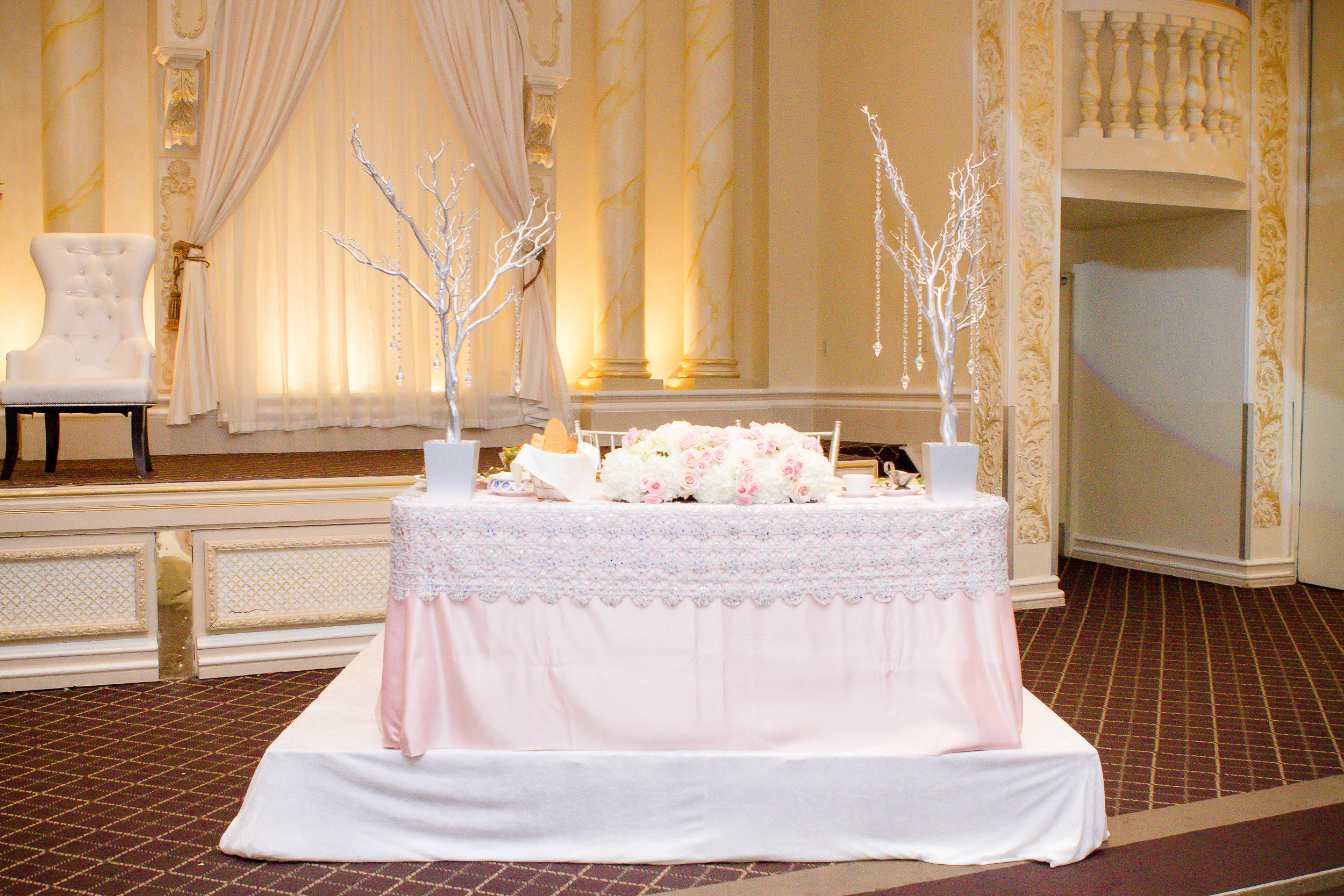 Wedding stage table decorated with flowers and elegant white branch centerpieces