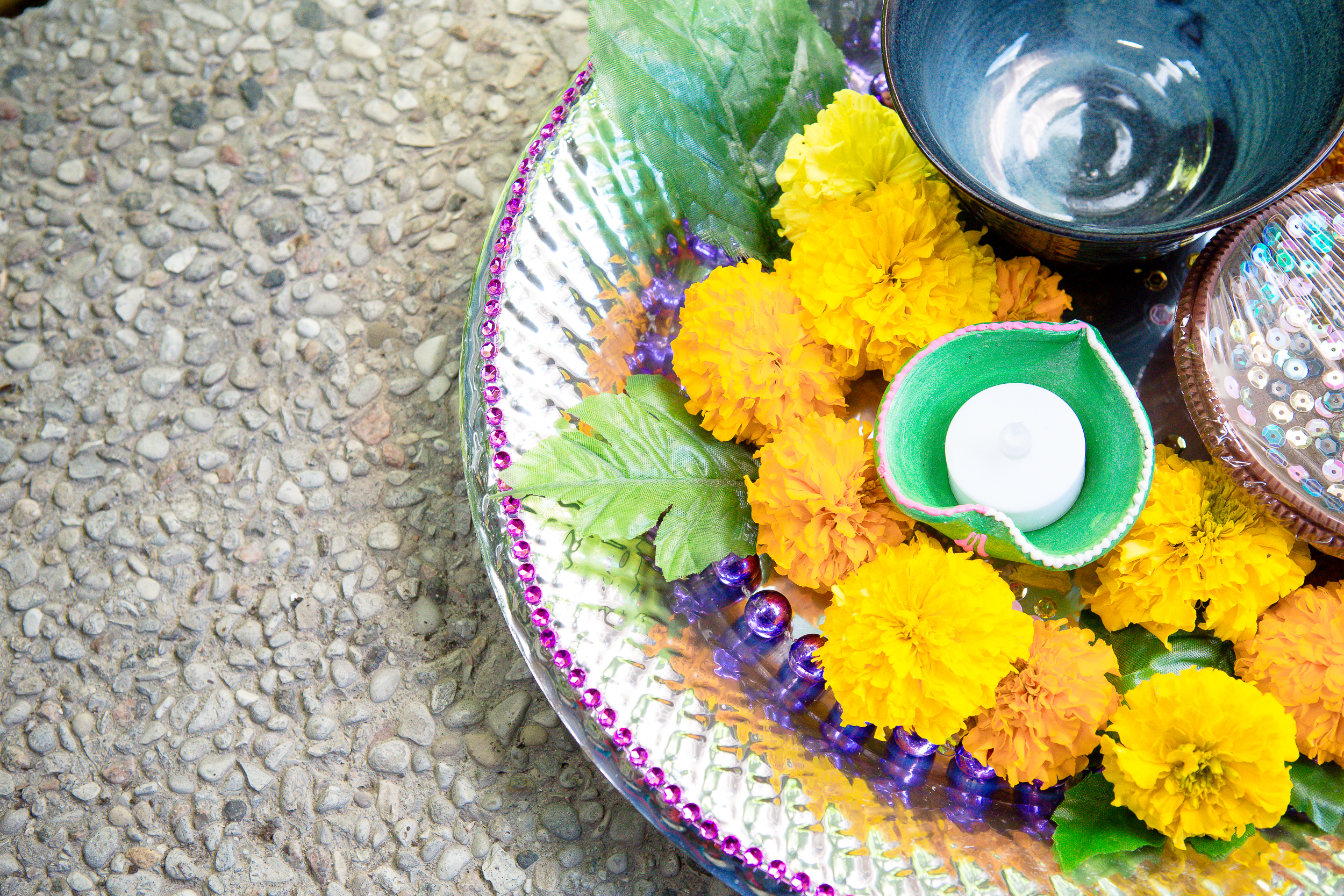 Decorative wedding tray with marigold flowers, candles, and ceremonial accessories